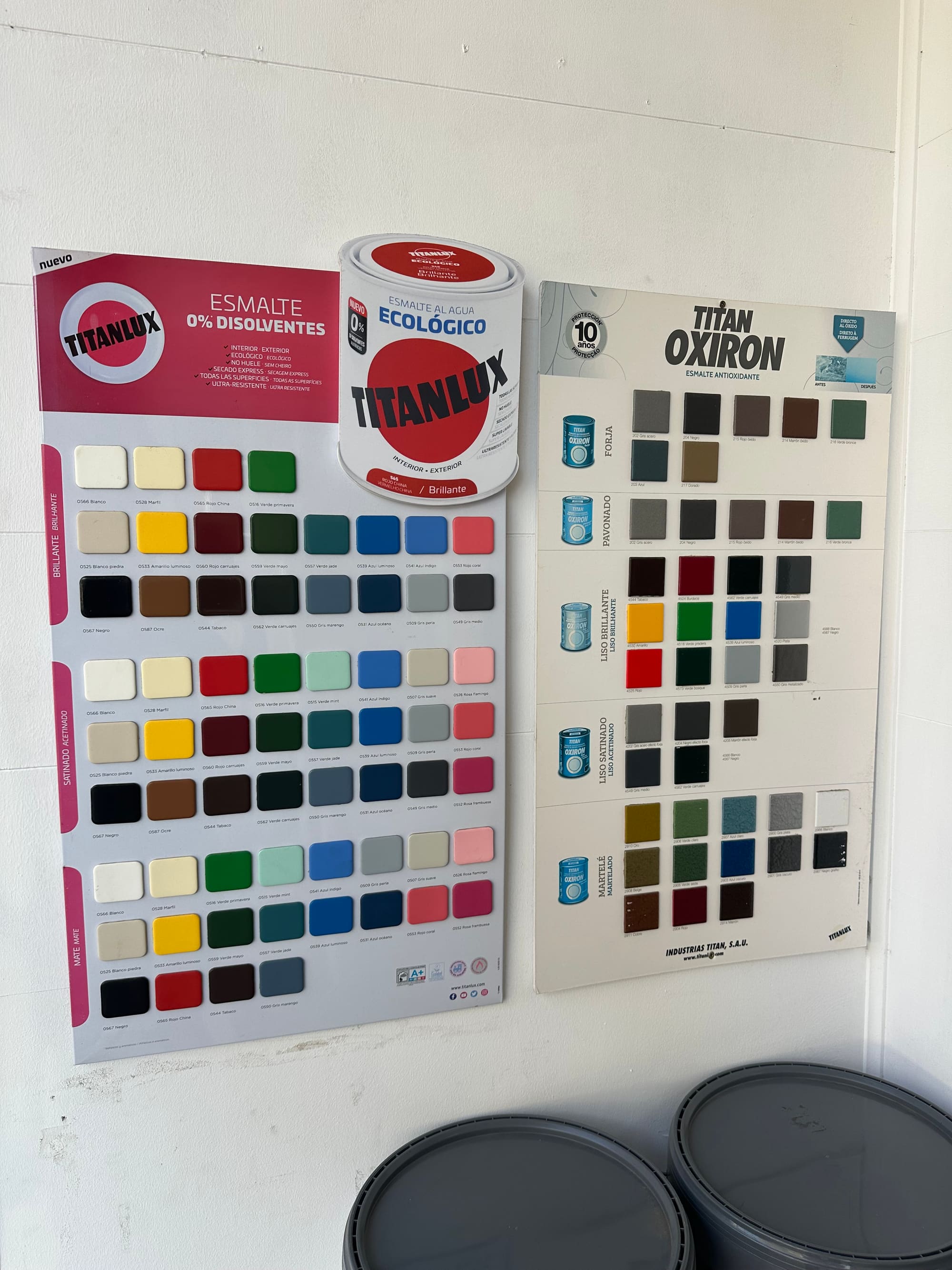 Cartas de color de esmaltes con decenas de tonos ordenados en cuadrícula, junto a una lata de Titanlux Esmalte Ecológico.